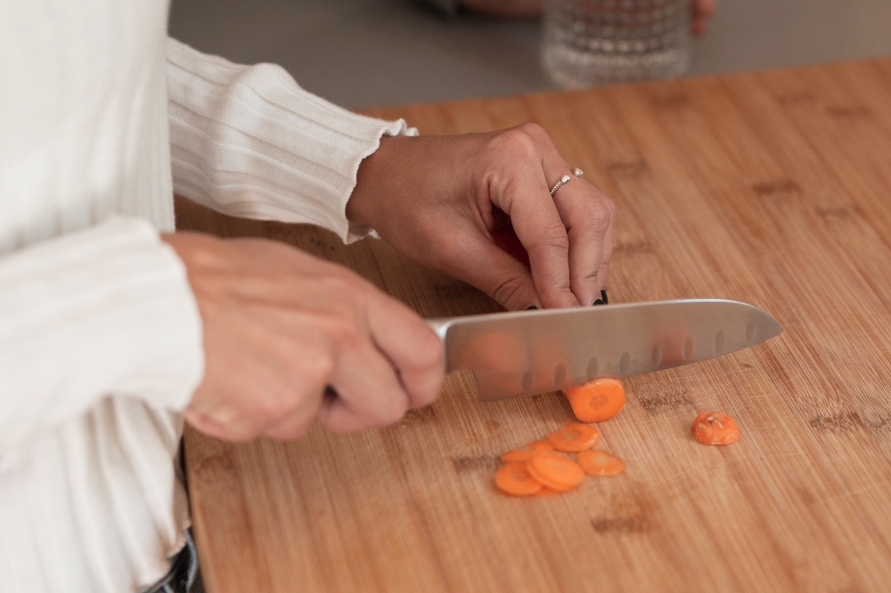 Close-up of a woman's hands cutting carrots on a cutting board